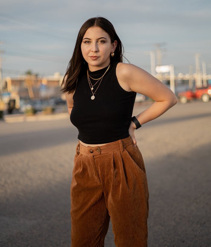 A woman in a black top and brown pants